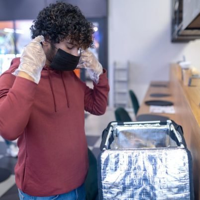 food-delivery-service-curly-haired-food-delivery-courrier-ina-protective-mask-work_259150-58594